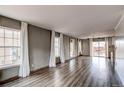 Open-concept living room with wood floors and large windows for natural light at 3607 Dinosaur St, Castle Rock, CO 80109