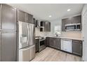 Modern kitchen with stainless steel appliances, ample counter space, and gray cabinetry at 1270 S Tennyson St, Denver, CO 80219