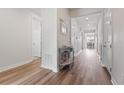 Bright hallway with hardwood floors leading to a dining area and multiple rooms at 7410 S Old Hammer Way, Aurora, CO 80016