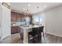 Bright kitchen features modern appliances, a center island with bar seating, and a beautiful backsplash at 7410 S Old Hammer Way, Aurora, CO 80016