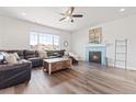 Spacious living room with hardwood floors, a fireplace, and lots of natural light at 7410 S Old Hammer Way, Aurora, CO 80016