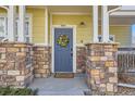 Close-up of front door with stone pillar accents and a decorative wreath at 9557 Pearl Cir # 204, Parker, CO 80134
