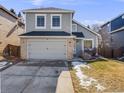 Charming two-story home featuring a gray exterior, brick accents, attached garage, and well-maintained lawn at 758 Poppywood Pl, Highlands Ranch, CO 80126