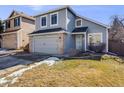 Charming two-story home featuring a gray exterior, brick accents, attached garage, and well-maintained lawn at 758 Poppywood Pl, Highlands Ranch, CO 80126