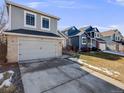 Charming two-story home featuring a gray exterior, brick accents, attached garage, and well-maintained lawn at 758 Poppywood Pl, Highlands Ranch, CO 80126