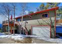 House exterior with deck and attached garage at 4969 S Indian Trl, Evergreen, CO 80439