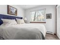 Cozy bedroom with a queen-size bed, soft white bedding, a blue headboard, and natural light at 4855 Edison Ave # 112, Boulder, CO 80301