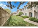 Serene backyard featuring a lush green lawn, privacy fence, and neatly trimmed bushes at 8475 Pebble Creek Way # 204, Highlands Ranch, CO 80126