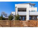 Modern two-story townhouse with a fence, front yard, and blue front door at 4335 N Pecos St, Denver, CO 80211