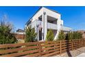 Modern two-story home with a balcony, manicured lawn, and a mix of concrete and wooden accents at 4335 N Pecos St, Denver, CO 80211