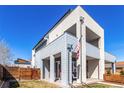 Modern two-story home with a balcony, manicured lawn, and a mix of concrete and wooden accents at 4335 N Pecos St, Denver, CO 80211