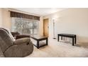Cozy living room featuring plush furniture, a coffee table, and sliding glass door at 2111 W 80Th Ave, Denver, CO 80221