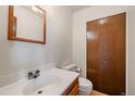 Clean bathroom with a white sink, wood-framed mirror, and a spacious closet at 14735 W Ellsworth Ave, Golden, CO 80401