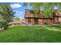 Charming brick townhouse with a well-maintained lawn and mature trees, offering a peaceful outdoor setting at 14735 W Ellsworth Ave, Golden, CO 80401