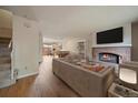 Cozy living room with a brick fireplace, modern furniture, and an open layout to the dining area at 14735 W Ellsworth Ave, Golden, CO 80401