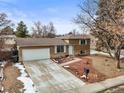 Aerial view of a tan two-story home featuring a two-car garage, long driveway, and minimal landscaping at 2911 S Olathe Way, Aurora, CO 80013