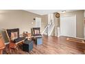 Cozy living room showcasing hardwood floors, neutral paint, a staircase, and traditional rocking chairs at 2911 S Olathe Way, Aurora, CO 80013