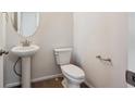 Compact half bath featuring a pedestal sink and white toilet at 1080 Joseph Pl, Erie, CO 80026