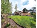 Expansive backyard featuring a well-maintained lawn, a spacious deck, and mature trees at 357 Saturn Pl, Lone Tree, CO 80124