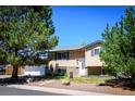 Charming two-story home boasts mature trees, a white garage door and inviting front entrance at 357 Saturn Pl, Lone Tree, CO 80124