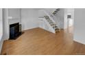 Open-concept living room featuring hardwood floors, a fireplace, and a staircase at 7604 S Steele St, Centennial, CO 80122