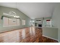 Spacious living room featuring vaulted ceilings, large windows, beautiful fireplace and gleaming hardwood floors at 6689 Kendrick Dr, Arvada, CO 80007