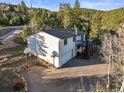 Exterior showcasing a two-story home with attached garage, basketball hoop, and ample parking on a paved driveway at 9790 City View Dr, Morrison, CO 80465