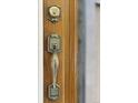 Close-up of the wood front door with decorative hardware and secure lock at 2140 S Washington St, Denver, CO 80210