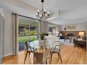 Bright dining area featuring wood floors, a glass table, and sliding doors to the backyard at 7405 S Jackson Ct, Centennial, CO 80122