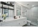 Modern bathroom with walk-in shower, updated vanity, stylish mirror, and floating shelves for storage at 3184 S Heather Gardens Way # 406, Aurora, CO 80014