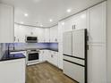 Clean kitchen features white cabinets, stainless steel appliances, and dark countertops at 3184 S Heather Gardens Way # 406, Aurora, CO 80014