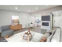 Living room with open layout, fireplace, recessed lighting, and views into the modern kitchen at 3184 S Heather Gardens Way # 406, Aurora, CO 80014