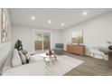 Cozy living room with modern furniture, light grey walls, wood-look floors, and balcony access at 3184 S Heather Gardens Way # 406, Aurora, CO 80014