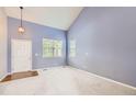 Spacious carpeted living room with a high ceiling and large windows at 2856 Penstemon Way, Castle Rock, CO 80109