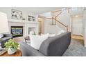 Cozy living room with fireplace and view of staircase at 7616 S Sicily Way, Aurora, CO 80016