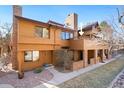 Charming multi-level townhouse featuring a brick chimney, a well-kept lawn, and wood-finished siding at 9400 E Iliff Ave # 37, Denver, CO 80231