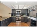 Spacious kitchen boasting stainless steel appliances, dark cabinets, granite countertops, and natural light from the window at 9400 E Iliff Ave # 37, Denver, CO 80231