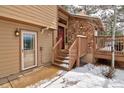 Inviting entrance featuring stone accents, wooden stairs and a covered doorway at 45 Oak Way, Evergreen, CO 80439