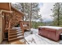 Outdoor hot tub with wooden deck and serene mountain views at 45 Oak Way, Evergreen, CO 80439