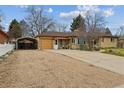 Ranch-style home featuring a large driveway, carport, and a fenced yard, perfect for outdoor living at 615 Estes St, Lakewood, CO 80215