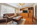 Bright living room featuring hardwood floors, a large window, and a wooden entertainment center at 615 Estes St, Lakewood, CO 80215