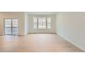 Spacious living room with sleek hardwood floors and abundant natural light streaming through large windows at 7367 S Yank Ct, Littleton, CO 80127