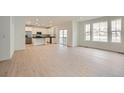 Open-concept living space featuring a kitchen, dining area, and living room with seamless flow and hardwood floors at 7367 S Yank Ct, Littleton, CO 80127