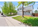 Two-story house featuring a lush green lawn, mature trees, and a concrete driveway at 9753 Gatesbury Cir, Highlands Ranch, CO 80126