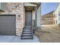 Close up view of the front door of the home, featuring stone veneer and a dark gray color palette at 1807 Grayside Cir, Castle Rock, CO 80109