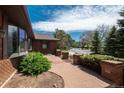 Brick walkway in front yard framed by verdant bushes and brick columns, leads to the house, enhancing curb appeal at 5361 Nassau Cir, Cherry Hills Village, CO 80113