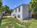 Spacious backyard with a grassy area, patio, and partial fencing, perfect for outdoor activities and relaxation at 1956 Cathay St, Aurora, CO 80011