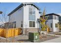 Two-story house with gray and white siding, a wooden fence, and a small front yard at 21021 E 63Rd Dr, Aurora, CO 80019