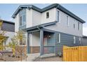 Inviting two-story home with a covered porch, manicured landscaping, and a distinctive red front door at 21021 E 63Rd Dr, Aurora, CO 80019