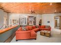 Living room with a cozy sectional sofa and views of the surrounding forest through large windows at 30174 Glen Eyrie Dr, Evergreen, CO 80439